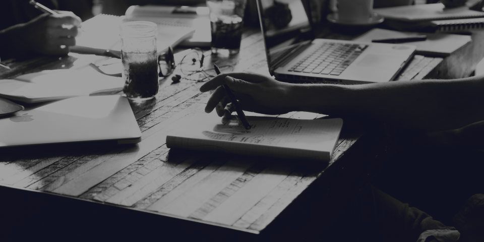 Several people going over documents and a laptop together at a table.